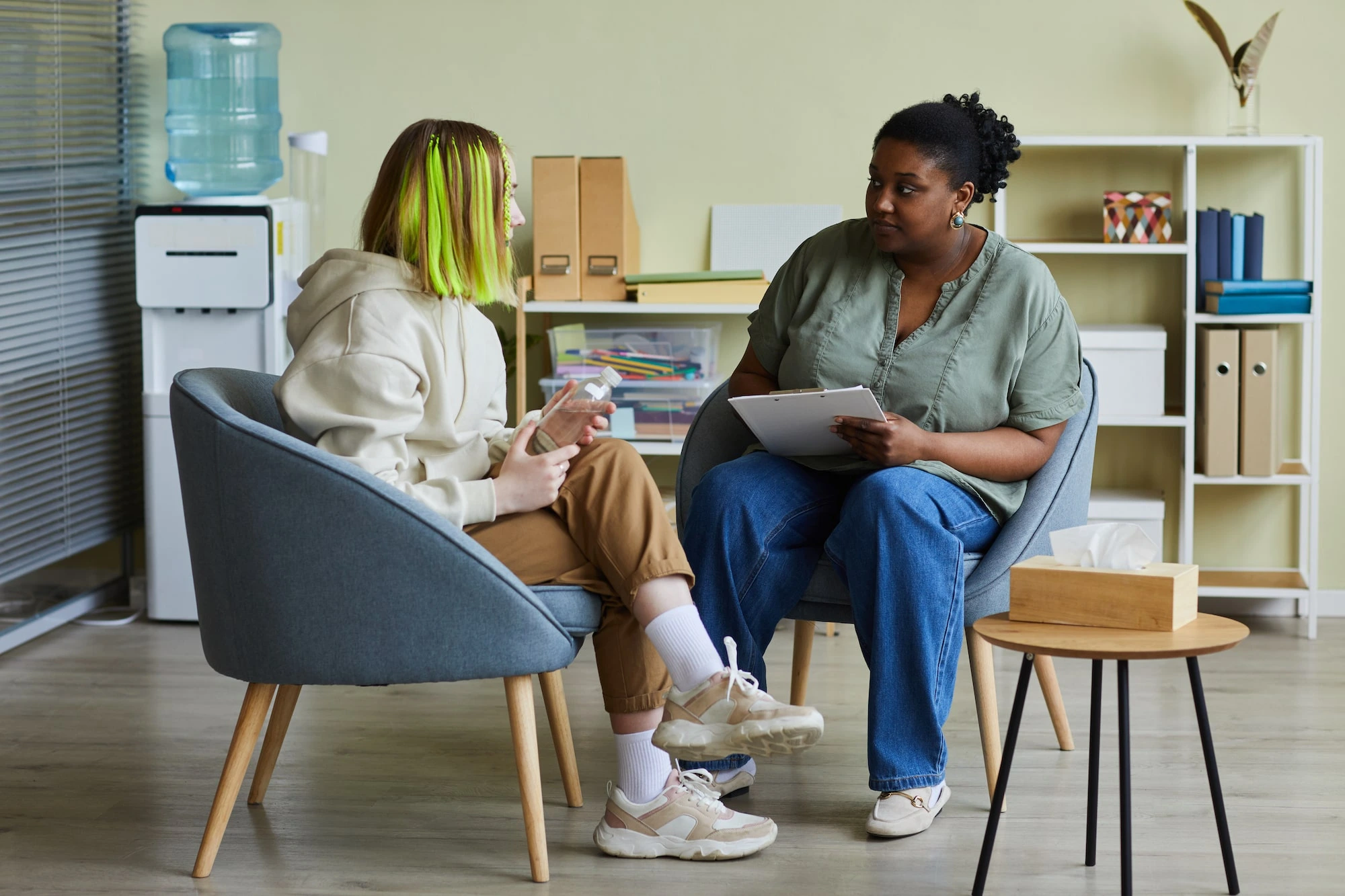 Photograph of a social worker speaking with a teenager.